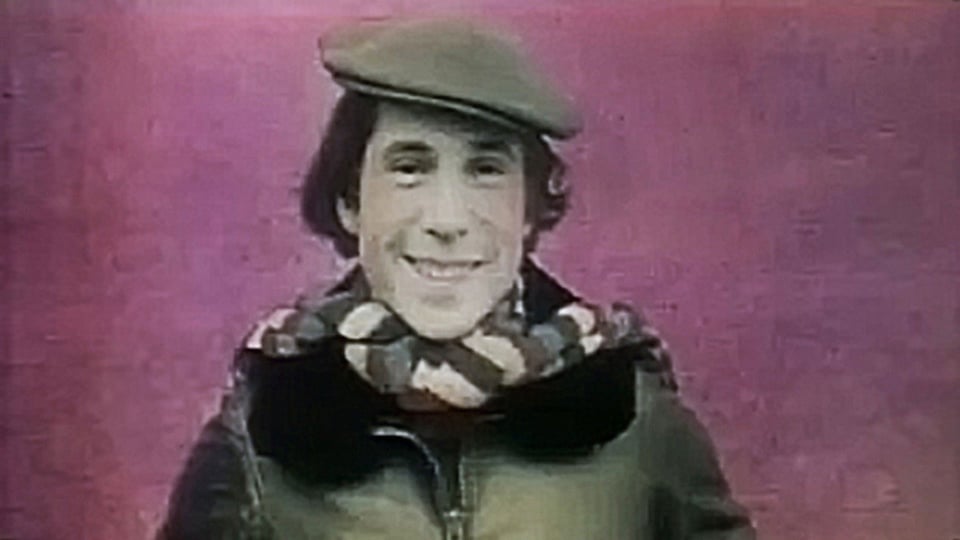 a young man wearing a hat and scarf