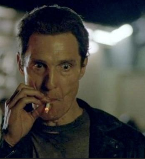 Matthew McConaughey taking a very strong drag on a cigarette. He looks very stressed.