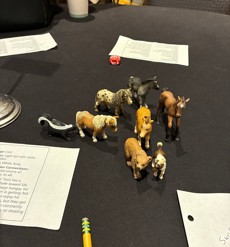 Plastic ponies, and a skunk and a bear, on a gaming table. Like miniatures. There's no hex grid, though.