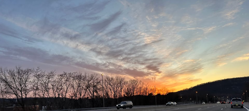Photo from car of sunset behind hills in northern NJ
