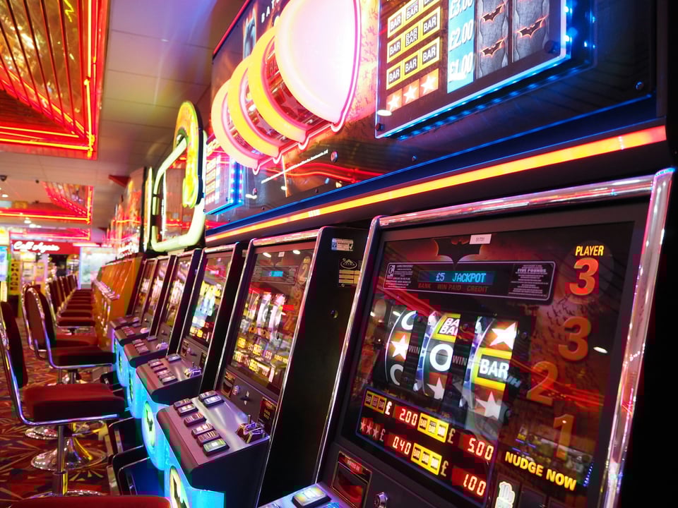 A row of casino-style slot machines. Photo by Lee Thomas on Unsplash.