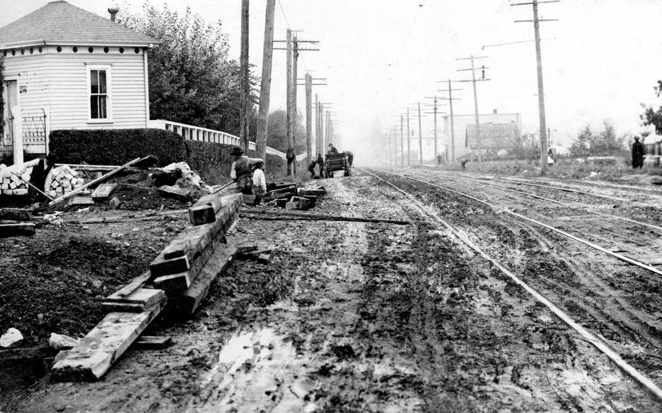 Image of an extremely muddy road with some telephone poles along side it.