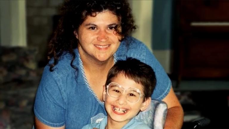 Dee Dee Blanchard with her daughter Gypsy Rose as a child, who is seated and wearing glasses.