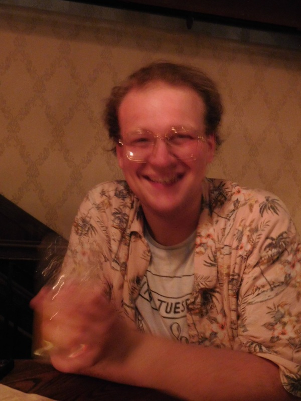 A blurry photo of Griffin, who is wearing a tropical shirt and a toothy grin