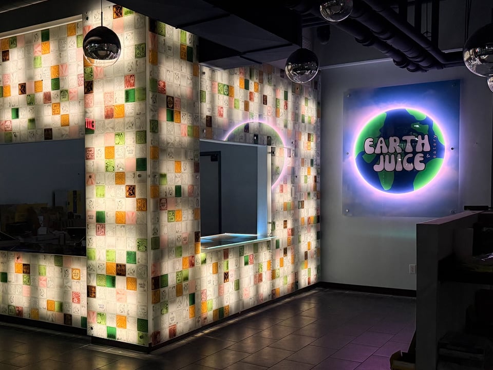 Neon and backlit tiles create a pretty disco ball infused juice bar, Earth Juice and Eatery.