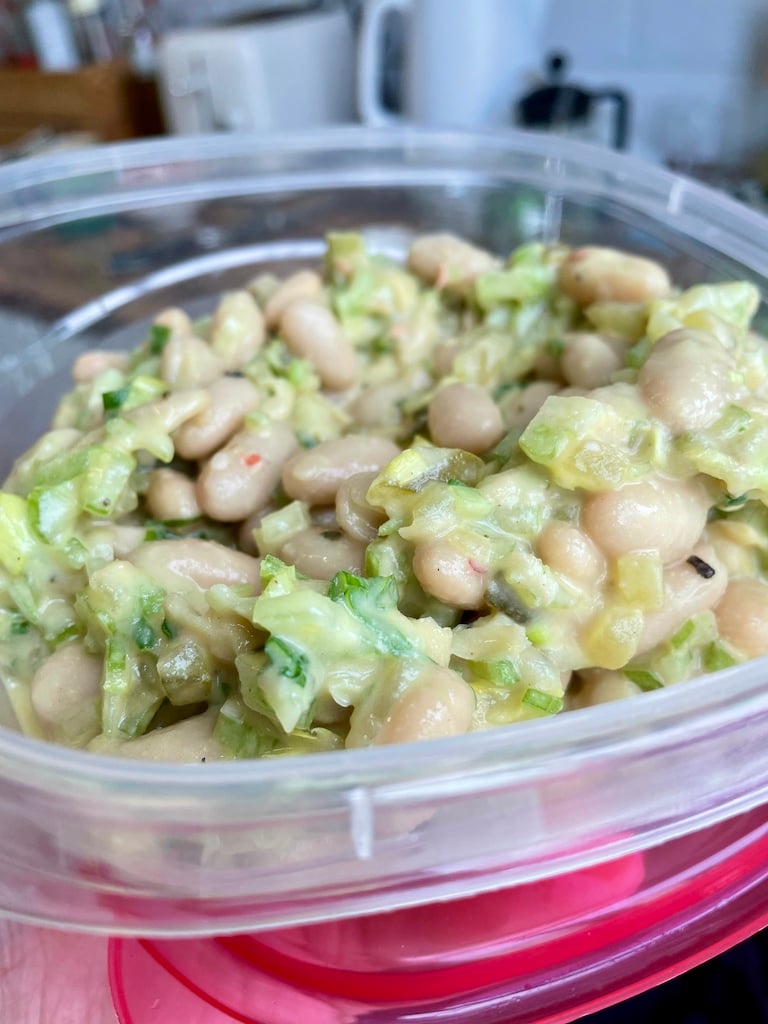 A tupperware of beans and chopped greens