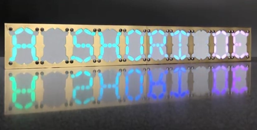 A lineup of ten of these newfangled 21-segment displays, spelling the words "A SHORT" following the two letters "DE" -- it seems clear that the words scroll rightwards, so the letters "DE" are the first two letters of a word yet to be revealed