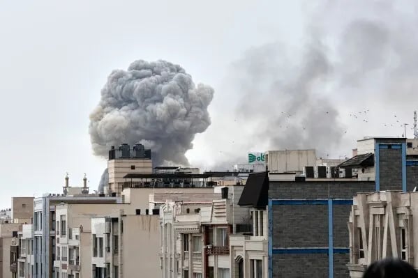 An AP photo of a neighborhood in Iran with an explosion in the background