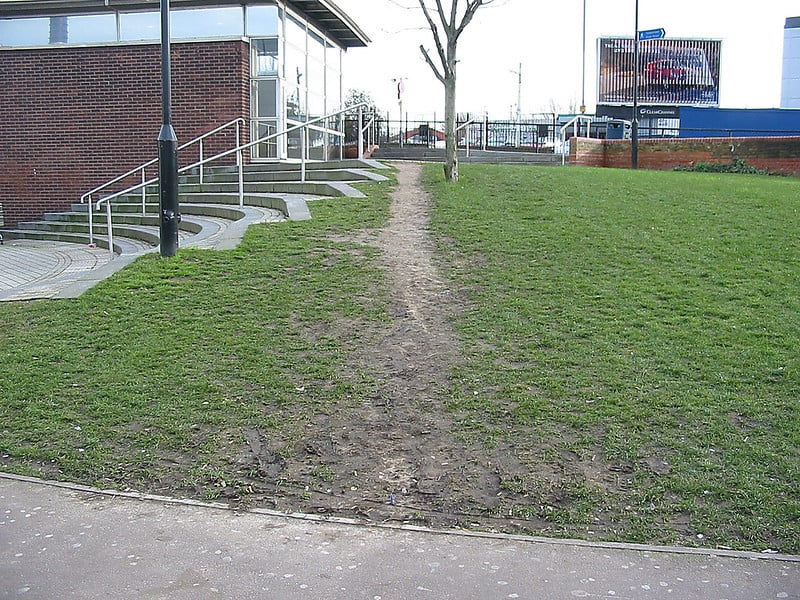 a dirt path next to a stairway