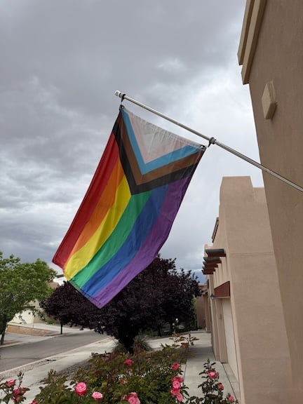 rainbow LGBTQ+ flag flown from an adobe house