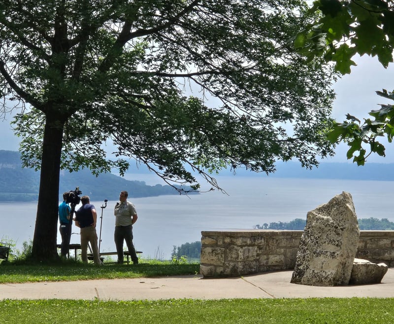We doubt that this WCCO TV crew (anchor/reporter Derek James and cameraman Dave Charest) have ever had a prettier backdrop for an interview than Lake Pepin as seen from Frontenac State Park’s iconic overlook. Here, in early June, they interviewed park manager Jake Gaster about the upcoming Prairie Dreams exhibit. / Photo by Pamela Miller