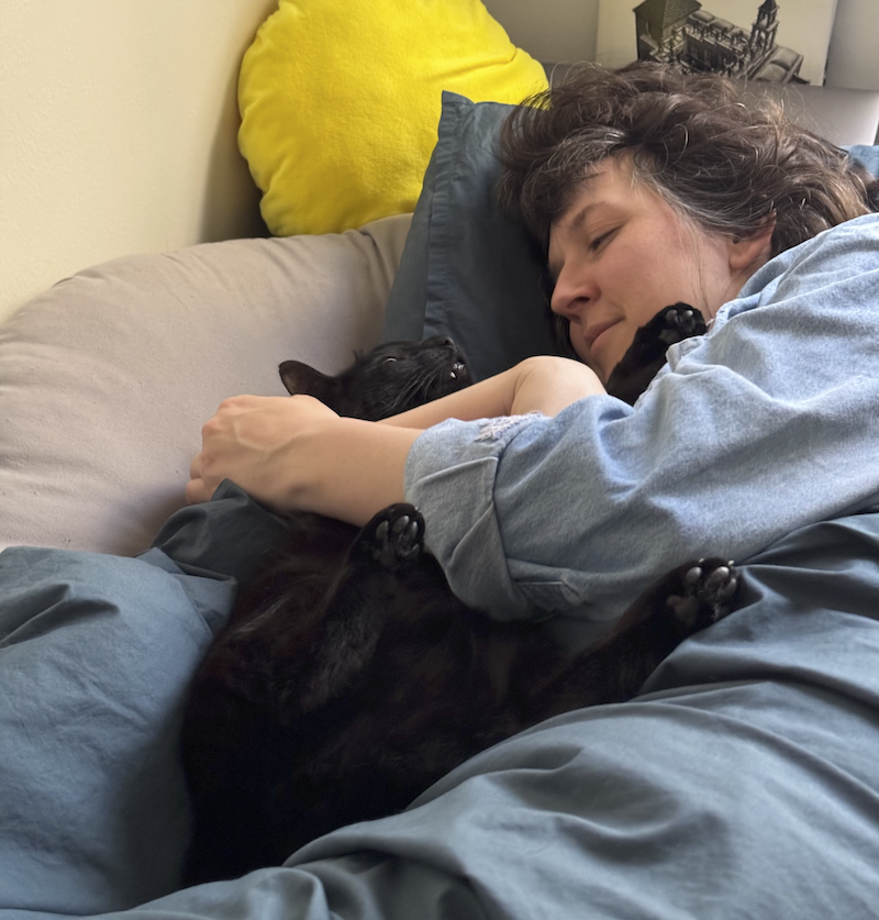 photo of me and my black cat pumagreg cuddling in bed