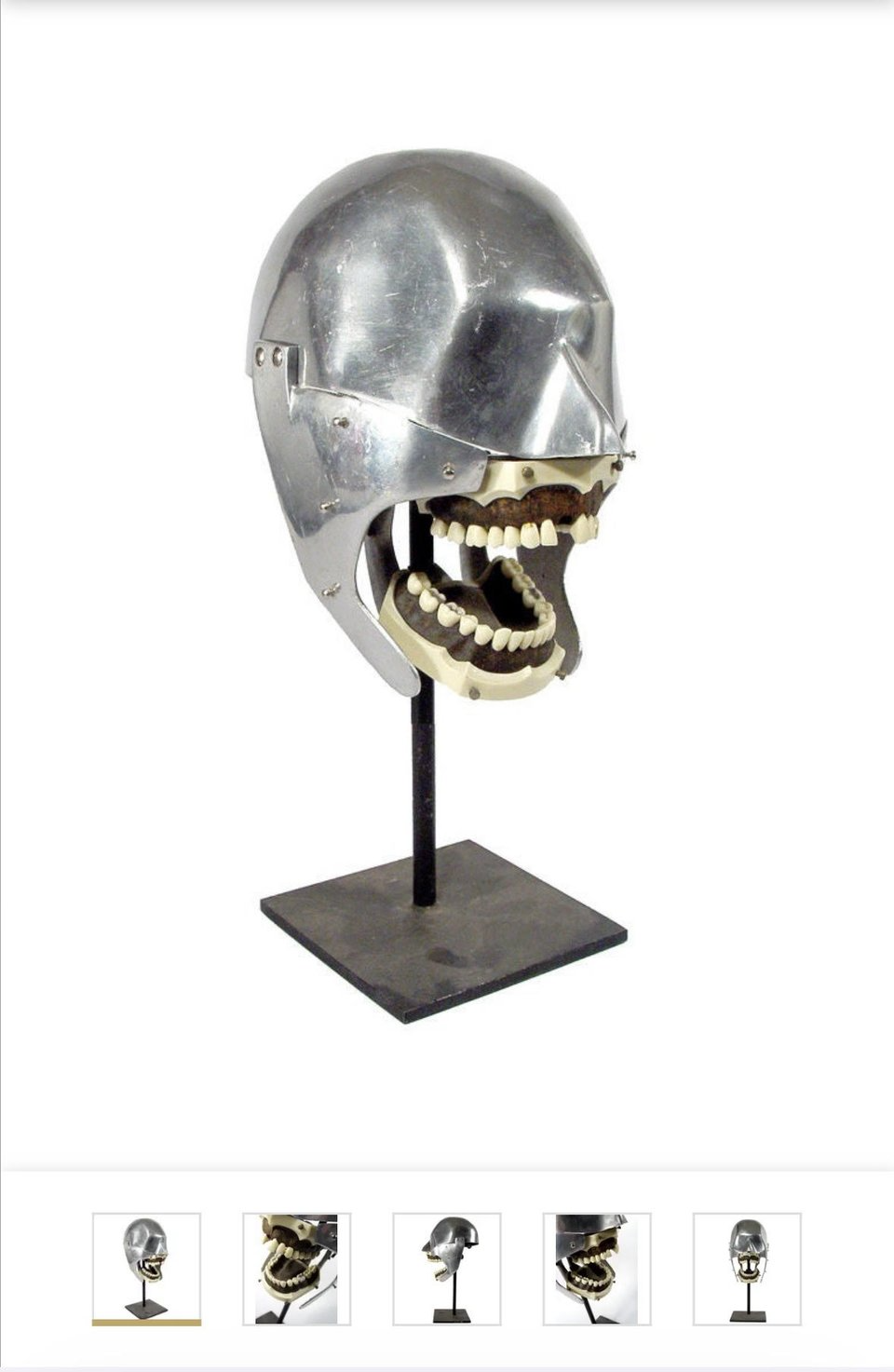 A horrible metal skull on a stand. Its mouth is open showing a full set of human-like teeth