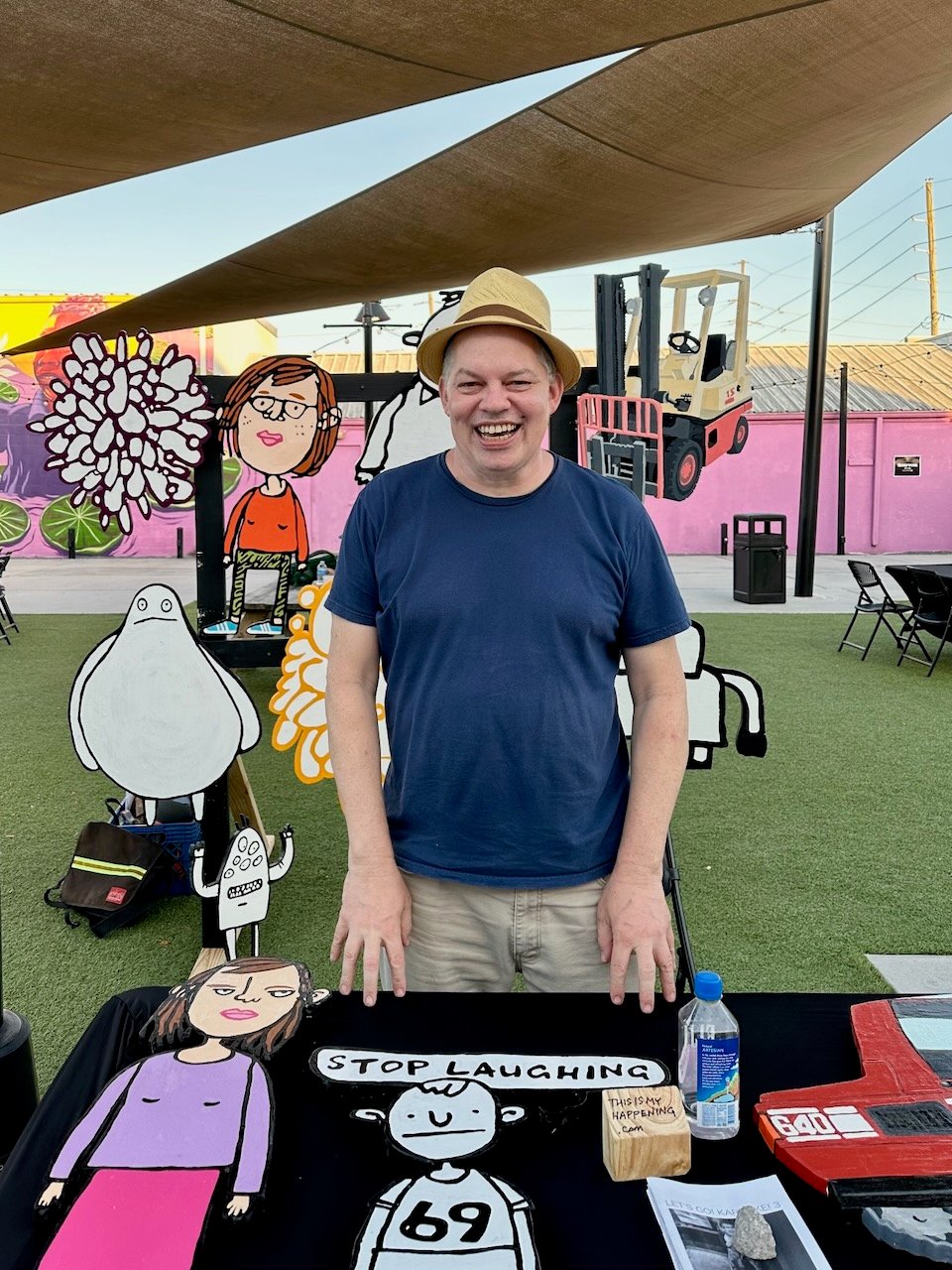 Dave Rhoden looking extremely ill-at-ease but smiling because he's being photographed at an art market