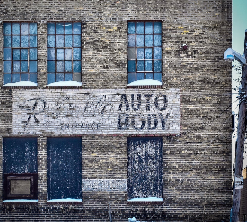 brick exterior of a building with faded, painted signs