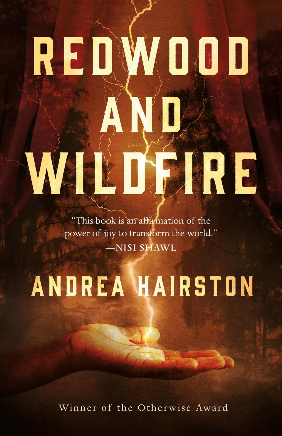 Cover of Andrea Hairston's novel Redwood and Wildfire with other text including Nisi Shawl's quote "This book is an affirmation of the power of joy to transform the world" and the note that the book is a winner of the Otherwise Award over an orange, red, and grey background depicting swamp pines in silhouette, while a dark-skinned hand reaches into the center of the bottom third of the cover to receive a lightning bolt that sparks down the center between the golden text