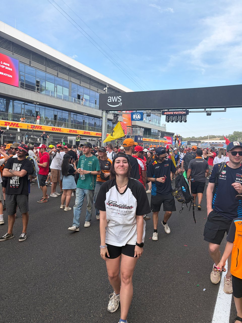 Woman standing on the race track with people surrounding her