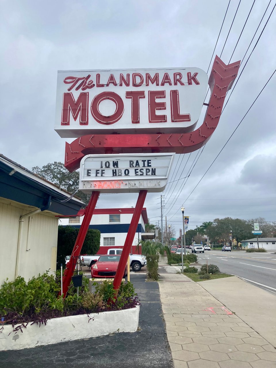 An old-style neon sign reading The Landmark Hotel attached to a small hotel front.