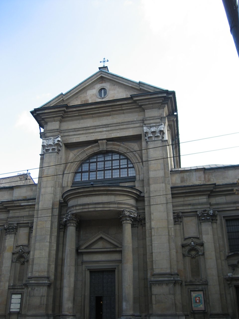 An elegant stone building with a large door and a tower above the door with a semi-circular window.