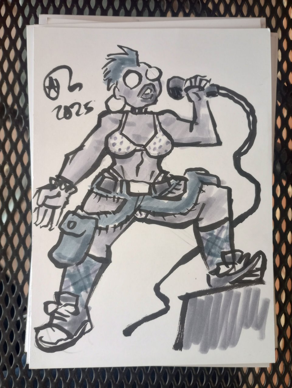 Val on stage in a bikini, argyle socks, sneakers, and the remnants of the cargo pants, which have been chopped down to the waist/belt and a couple of strips with the pockets hanging off of them