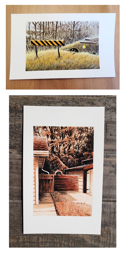 Two photographs of two paintings, of my "Little Guys" series. The first is of two of the Little Guys, little black blobs with white eyes and small arms, crawling out of the ditch at an abandoned rail crossing. The second painting is a monochrome piece in brown tones, of the same Little Guys peering over a fence next to a garage and an adjoining house, with tall coniferus trees in the background.