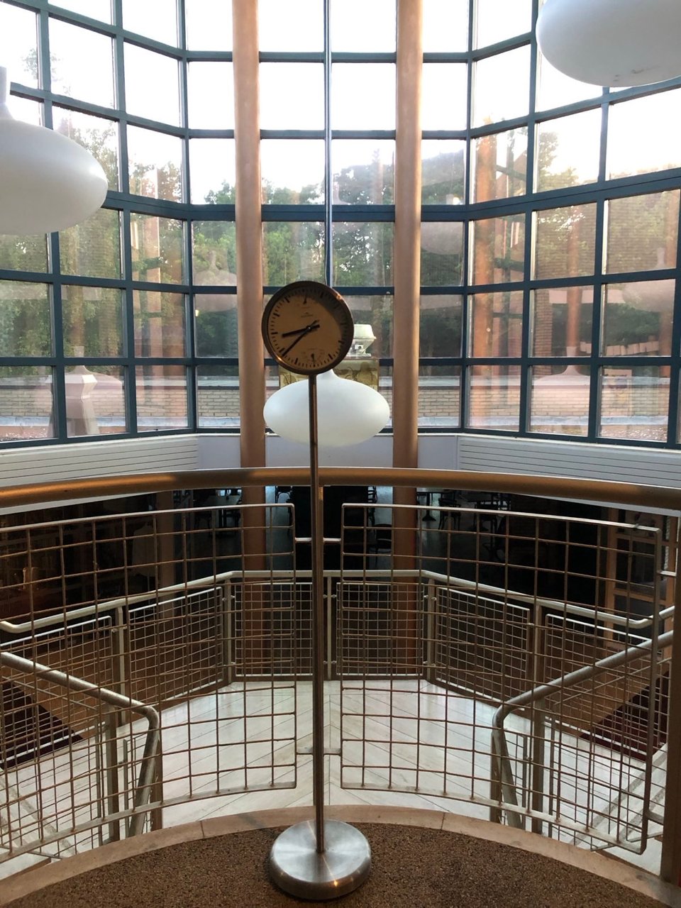 A tall and minimal steel clock stands in the middle of a double stairway at ‘t Olderloug in Slochteren, The Netherlands.