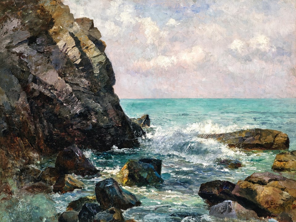 Waves from a blue green sea breaking against dark rocks