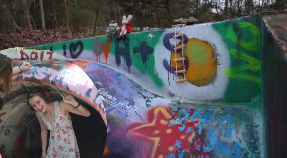 At the mouth of the tunnel in an abandoned, grafitti-covered concrete waterslide, you can see a 17-year old Copeland poking their head out and smiling. On top of the tunnel, a knit frog and rabbit are perched.