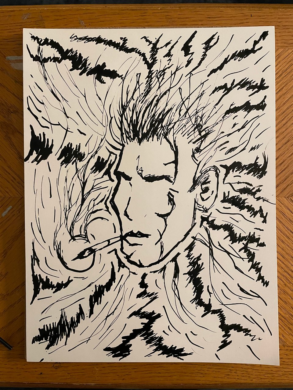 An ink drawing of an abstract face surrounded by jagged and flowing lines of energy