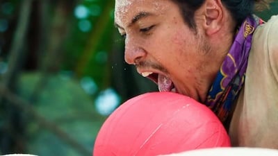 a man licking a red ball