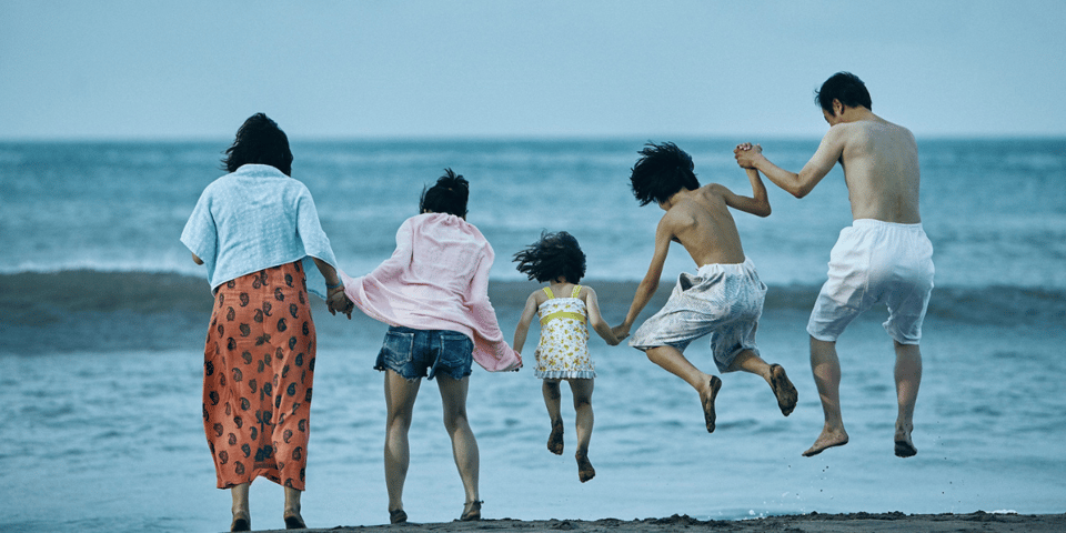a family jumping on the beach