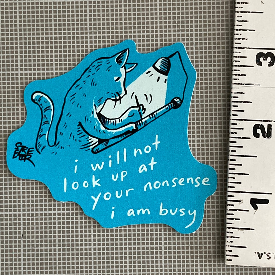 Photo of a sticker of a cat with caption "I will not look up at your nonsense I am busy"