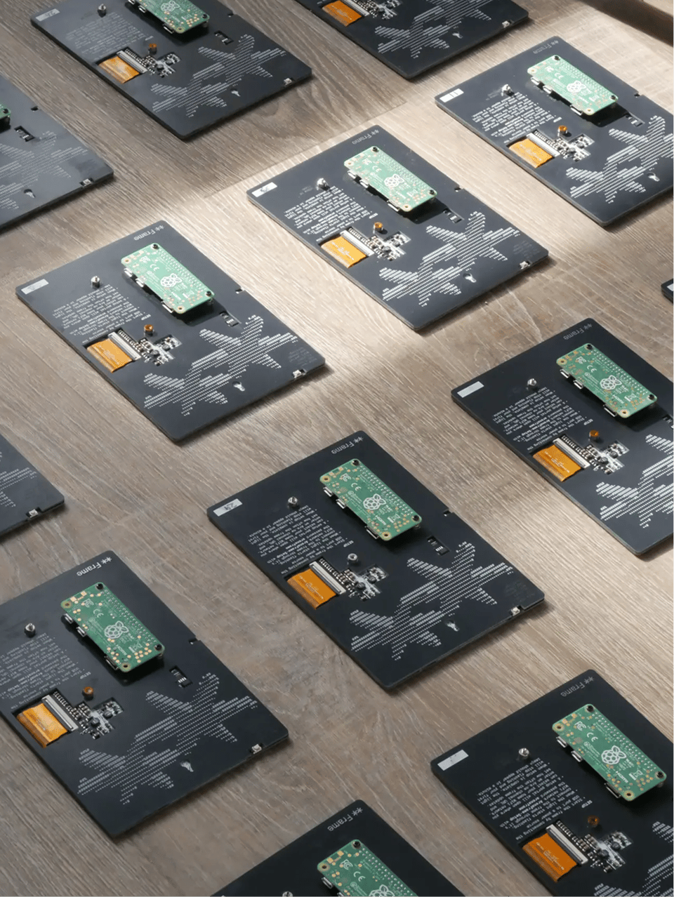 Several Are.na frames lined up on a table, shown from behind, with their circuitry exposed.