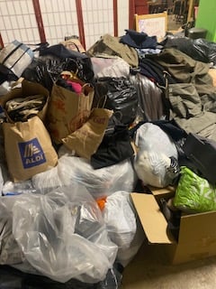 A very large pile of boxes and bags of donated clothing and shoes