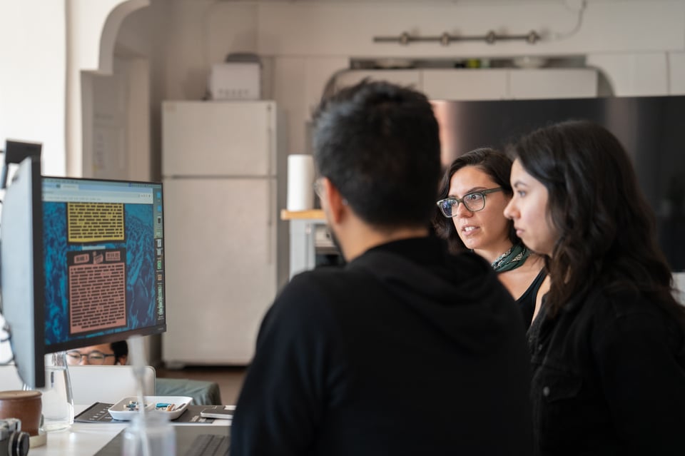 A group of people looking at a screen.