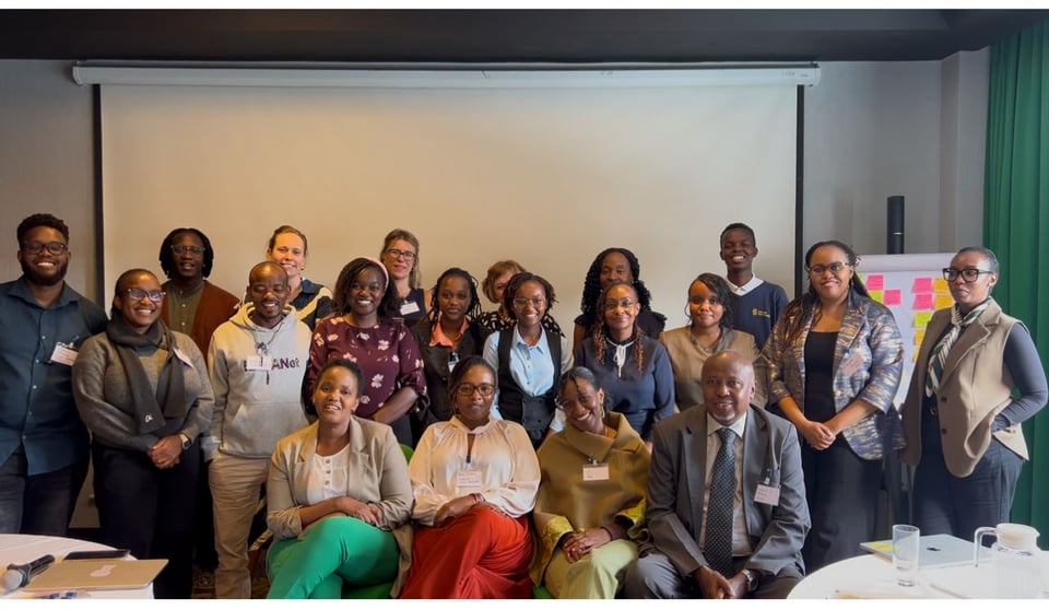 A photo of about 20 people in a hotel meeting room, all very smartly dressed