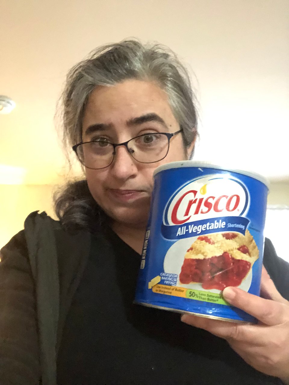 A selfie of your intrepid newsletter author looking bemused as she holds up a can of Crisco the size of her head