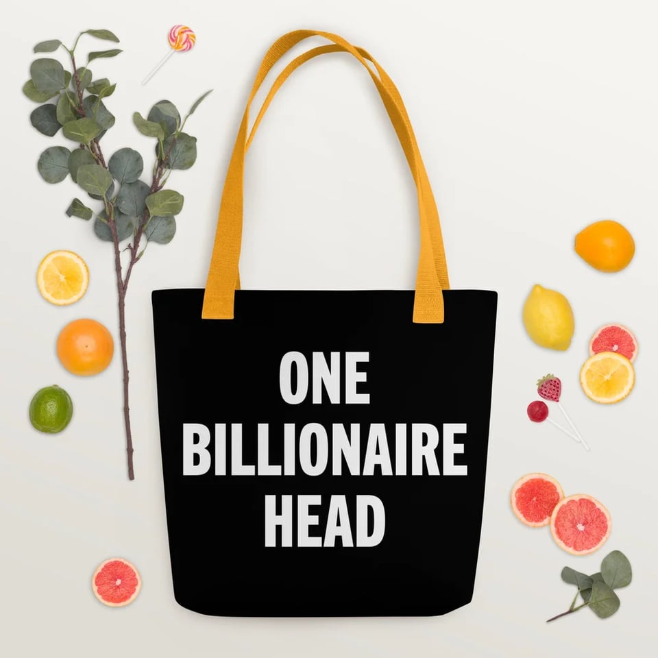 A very nice black tote bag with yellow handles that says ONE BILLIONAIRE HEAD. Surrounded by slices of fruit and leaves for some fucking reason.