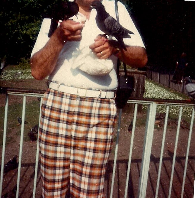 closeup of bottom half of man in loud plaid pants feeding pigeons in Hyde Park, London, 1980