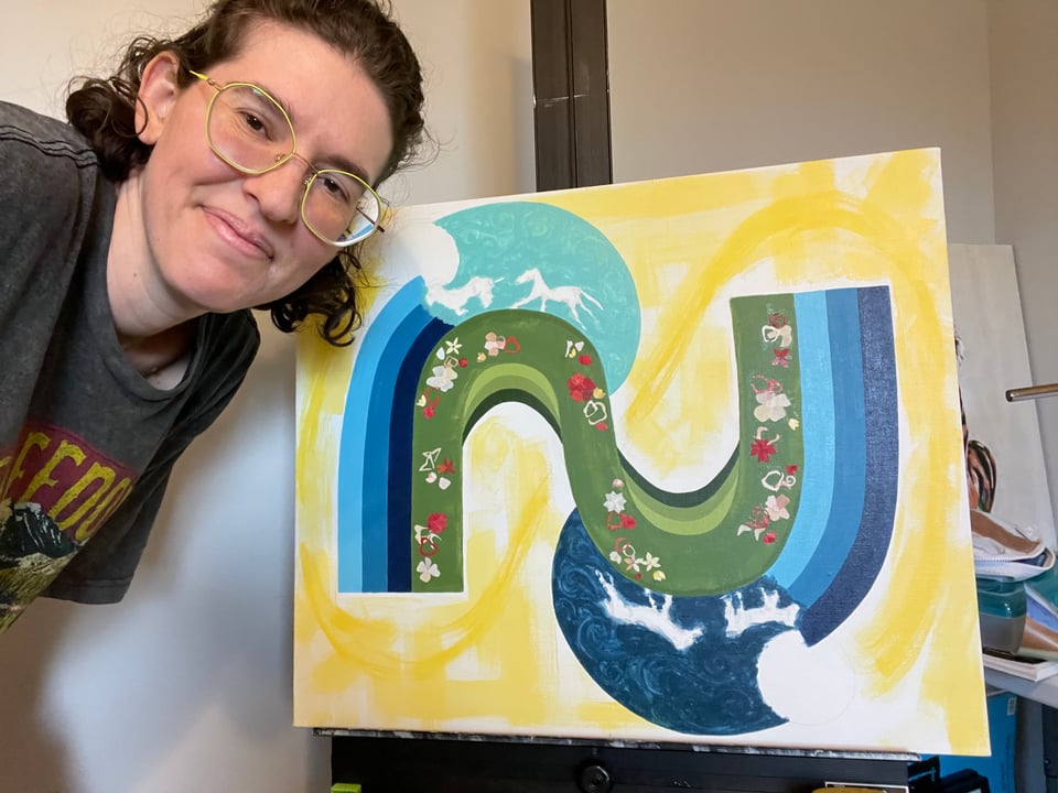 Image of myself standing next to the canvas that shows the beginning stages of "Cycles." You can begin to make out the flower-like paper collage in the green N-like swoop, with three shades of blue stripes emanating from it. There are outlines of two horses on the top left, with a light blue background, and two horses on the bottom right, with a dark blue background. The furthest background is yellow.