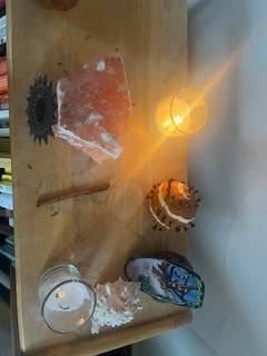 sideways view of an altar, with selenite, a glowing votive, and other small winter offerings