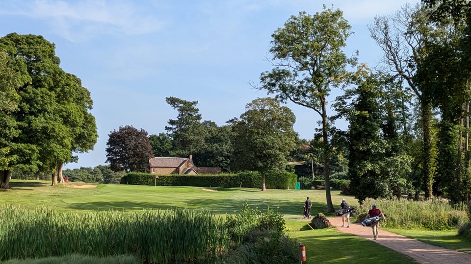 Frilford Heath par 3 9th hole, three friends walking over a small bridge to the green