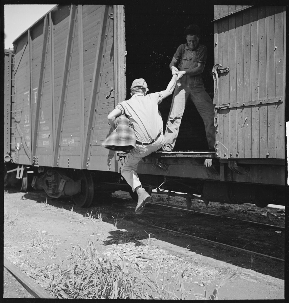 Deux vagabonds se tenant la main pour monter dans un train