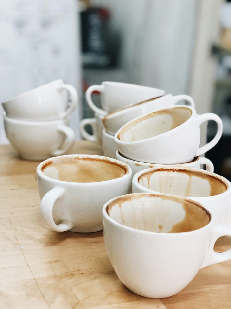 a group of white coffee cups on a wooden table