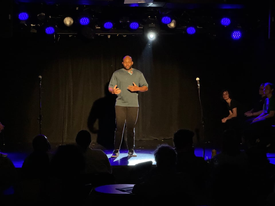 Julien is onstage giving a monologue with an audience in the foreground