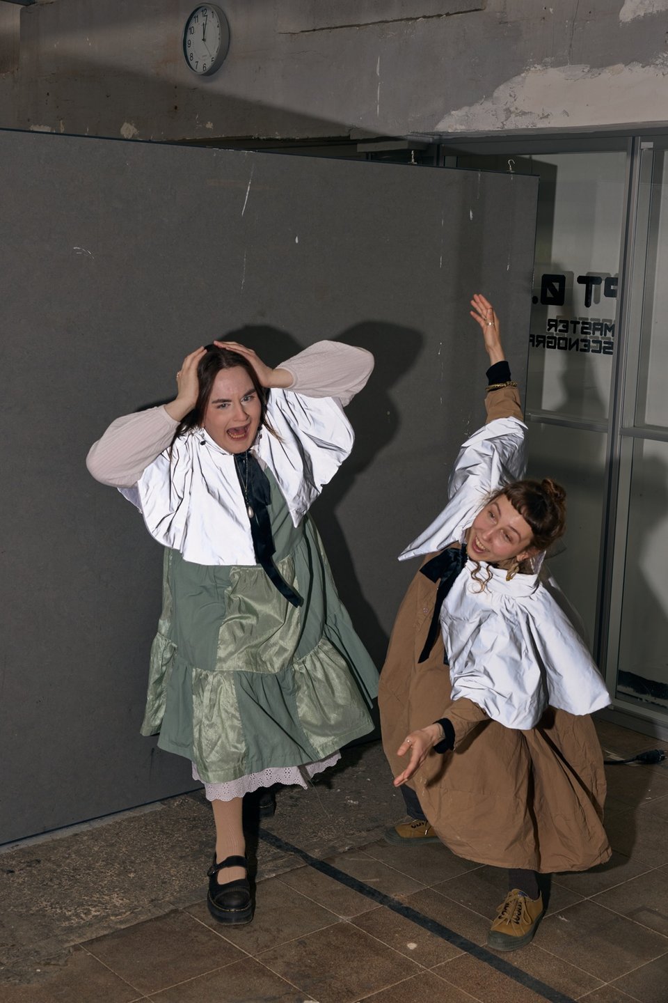 two people in costume react dramatically to an unseen off-frame event