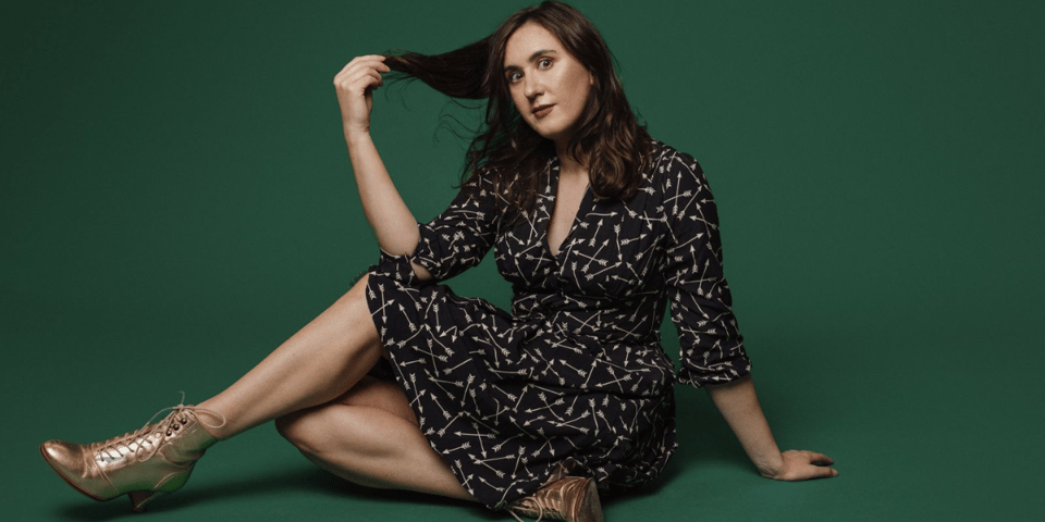 Charlie posing in front of a green background.