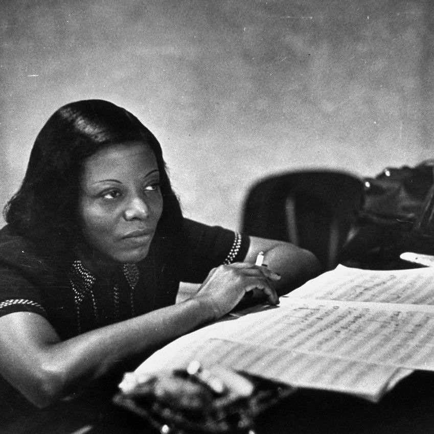 Mary Lou Williams sitting at a piano with manuscript