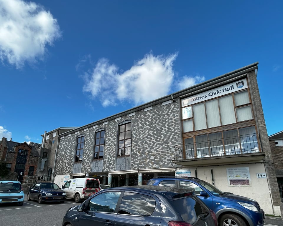 The rear wall of the Civic Hall. The blank slate wall has had three tall 2 by 8 windows cut in. Their tops are curved, and the slates below them have been replaced with leading. The windows are clearly out of proportion with Jellicoe's glass cube foyer block.