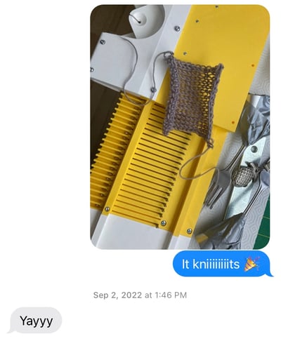screenshot of an IM conversation featuring an image of a 3D printed knitting machine prototype with a small knitted fabric swatch; the accompanying message reads: "it kniiiiiiiits (party emoji)"; with the reply: "Yayyy"